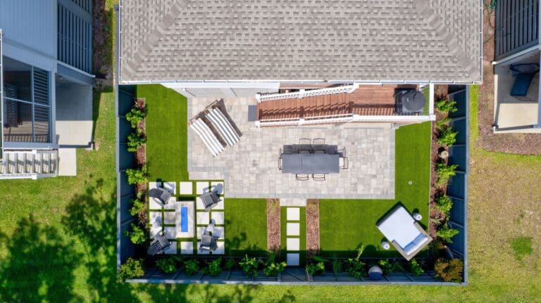 Overhead view of a fully designed Lowcountry backyard showing the site plan in practice, with a paver patio, lawn panels, planting beds, and spa laid out as one composition